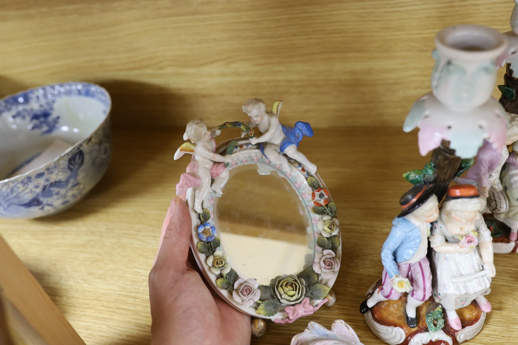 A pair of 19th century continental porcelain figural candlesticks and a group of four similar frames